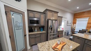 A modern kitchen with granite countertops, stainless steel appliances, and wooden cabinetry. - Veteran’s Family Retreat, Spacious & Peaceful Stay Near AFB (Sherwood)