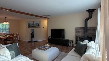 A living room with a sofa, a coffee table, a TV, and a fireplace.