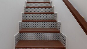 Un escalier orné de carreaux décoratifs et doté d’une main courante en bois.