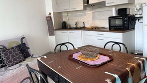 Eine kleine Küche mit weißen Schränken, einer Mikrowelle und einer Kaffeemaschine.
