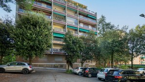 A multi-story residential building with balconies, parked cars, and trees. - GuestHost - 90 sqm apartment for 4 people in Perugia, with a balcony and unassigned on-site parking. Located just a 10-minute walk from the historic center, it offers tranquility without sacrificing convenience. Perugia, renowned for its rich medieval hi (Perugia)