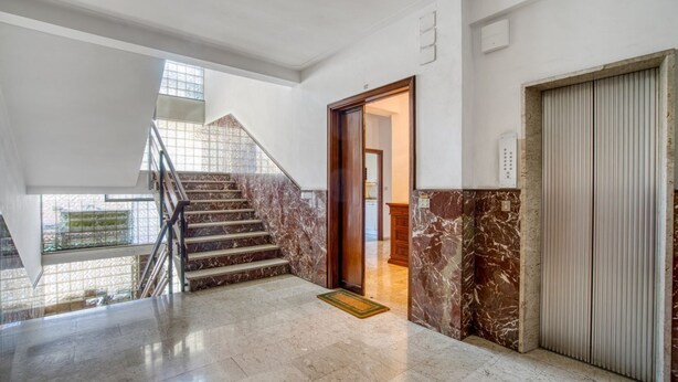 A spacious interior with a marble staircase, a closed elevator, and a view through a glass door. - GuestHost - 90 sqm apartment for 4 people in Perugia, with a balcony and unassigned on-site parking. Located just a 10-minute walk from the historic center, it offers tranquility without sacrificing convenience. Perugia, renowned for its rich medieval hi (Perugia)