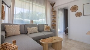 A modern living room with a grey sectional sofa, a round coffee table, and a wicker basket.