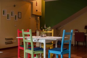 Enjoy meals with family and friends in this cozy dining area, featuring a table for four and vibrant chairs.