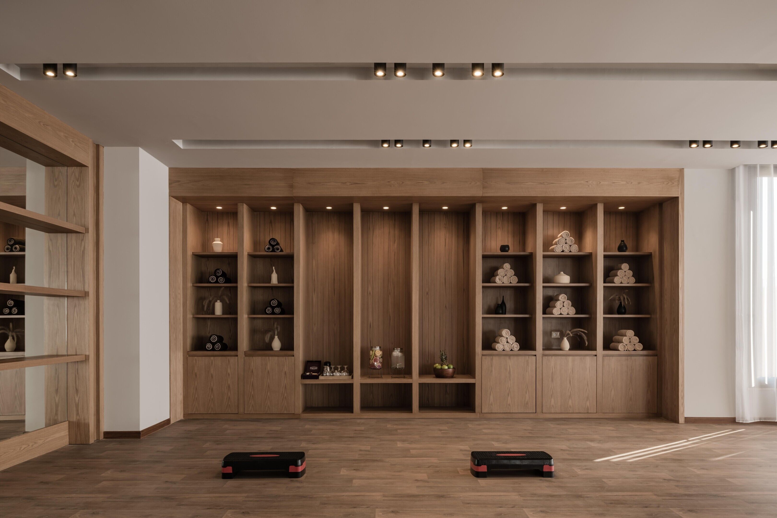 Een modern interieur met houten schapenkasten, inbouwverlichting en een houten vloer.