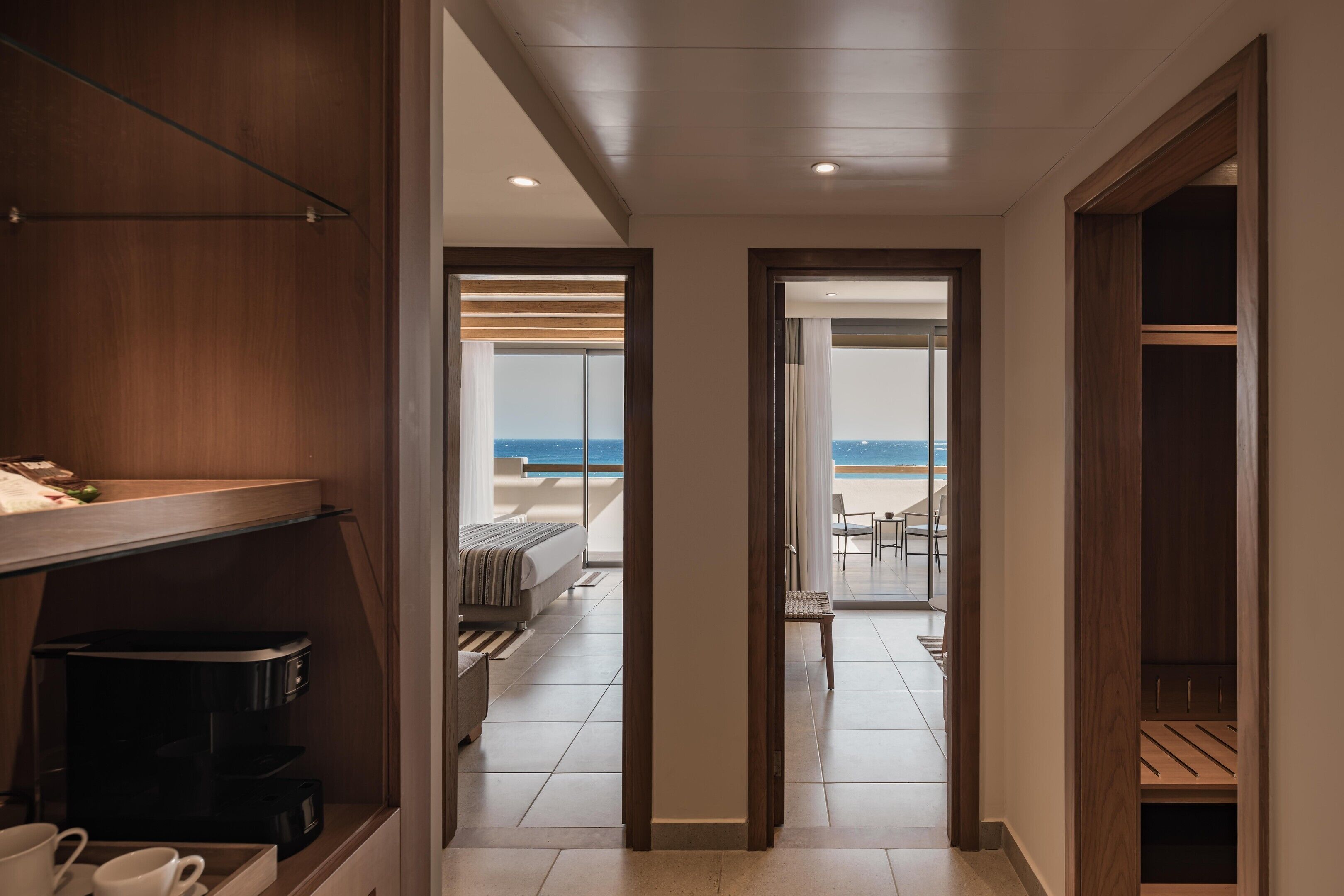 A hallway leading to a balcony with a view of the sea.