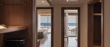 A hallway leading to a balcony with a view of the sea.