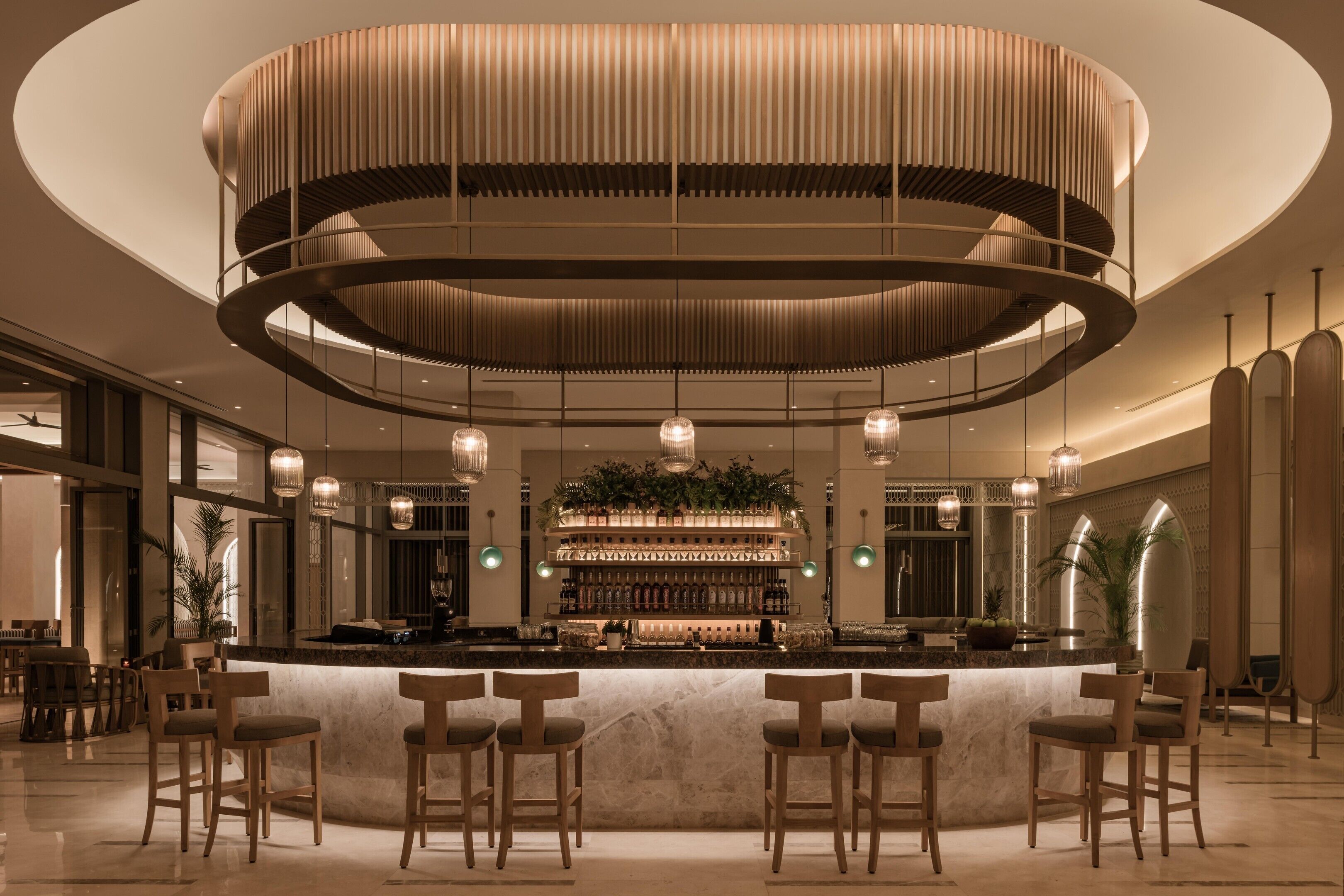A bar area with a circular design, bar stools, and a central bar counter.