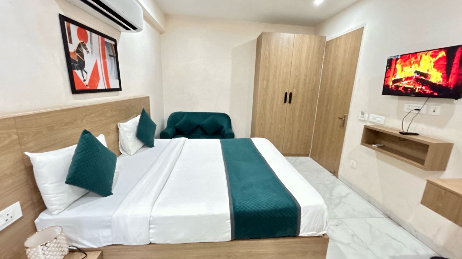 Une chambre d’hôtel avec un lit, une télévision, une armoire et un tableau au mur.