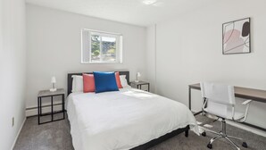 Ein Schlafzimmer mit einem Bett, einem Schreibtisch und einem Stuhl.