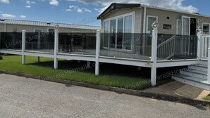 Un bâtiment de style caravane doté d’un espace extérieur couvert, d’un escalier et offrant une vue sur le ciel.