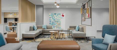 Una sala moderna con un conjunto de sofá, una mesa de centro y un sillón azul.