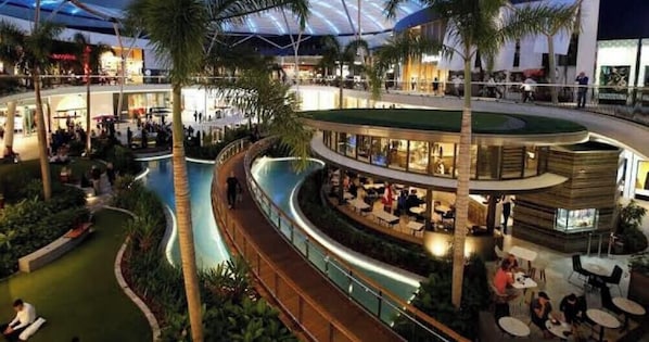 Un atriumo interior con una piscina central, varias zonas de comedor y un paseo cubierto.