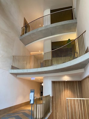 Ein mehrgeschossiges Interieur mit Betontrelagen und einer Wandpaneelverkleidung aus Holz.
