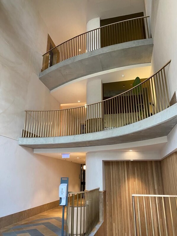 A multi-level interior with concrete railings and a wooden panel wall.