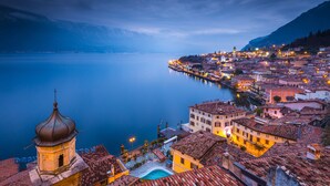 Une ville côtière dotée de bâtiments historiques, d’un clocher et d’un lac paisible.