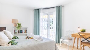 A neatly arranged bedroom with a bed, a desk, and a chair. There is a bookshelf with books and a potted plant. - Calahonda Golf in Calahonda (Mijas)