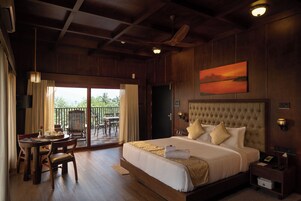 Un dormitorio amplio con una cama grande, un comedor con mesa y sillas, y un balcón con vistas.