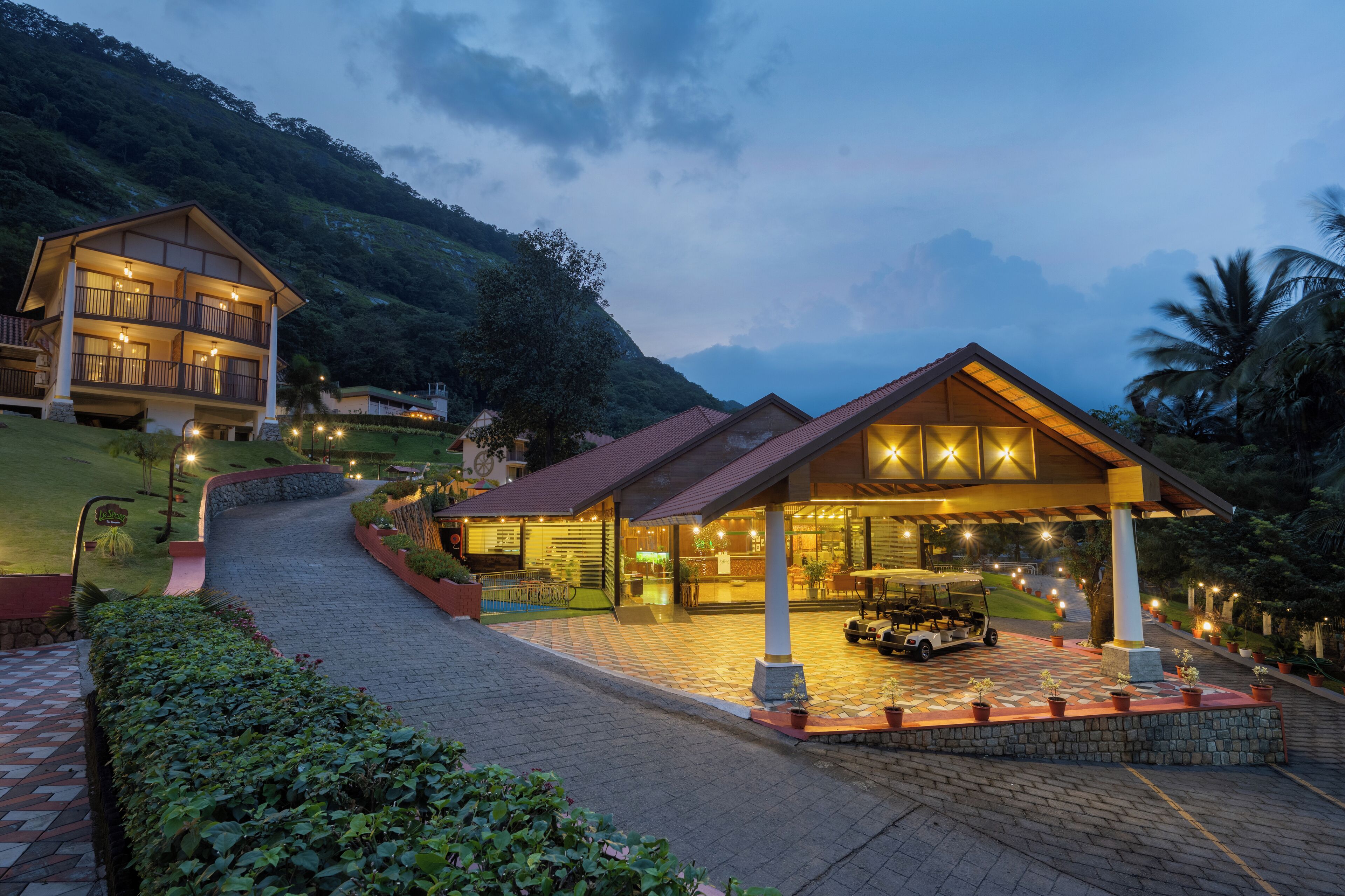A hotel with a spacious entrance, a golf cart, and a well-lit driveway.