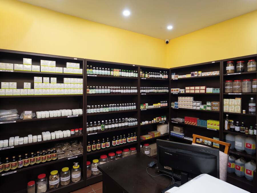 Un almacén bien organizado con estantes llenos de diversos productos, una computadora y un escritorio.