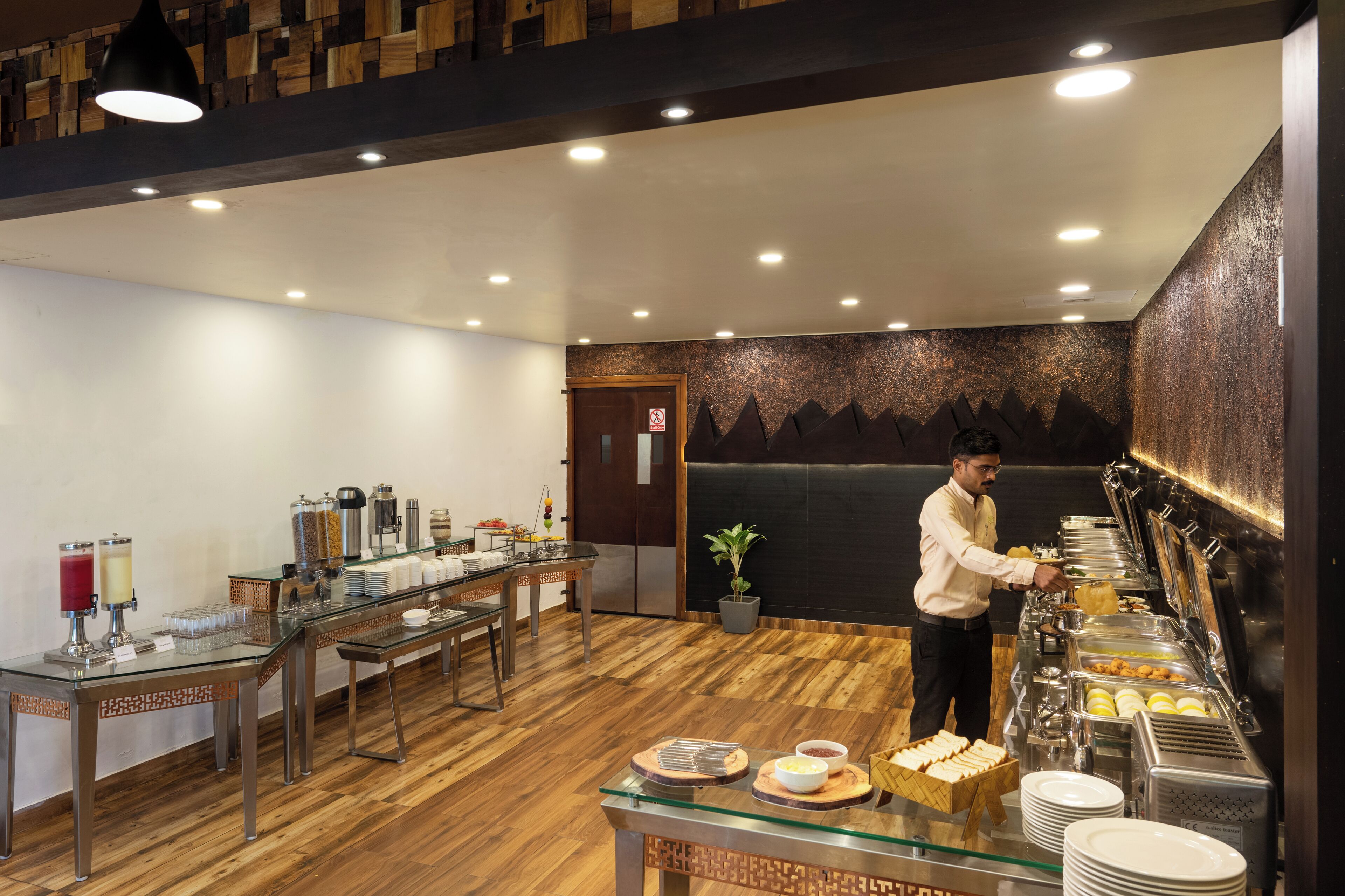 A buffet setup with a variety of food items and a staff member serving.