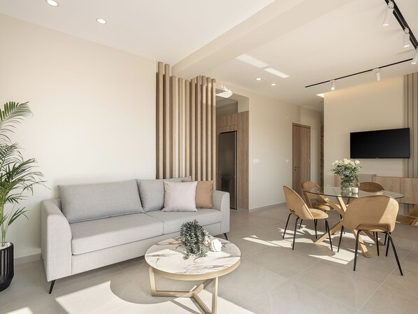 Una sala de estar moderna con un sofá, una mesa de centro y un comedor.