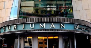 Burjuman UOM features a sleek, curved entrance and expansive glass windows.