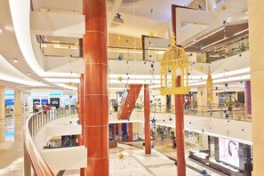 Experience the sleek, multi-level shopping mall with a spacious layout and polished tile floors.