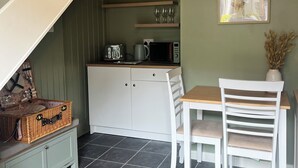 A kitchen with a dining area, a staircase, and a wall-mounted picture.