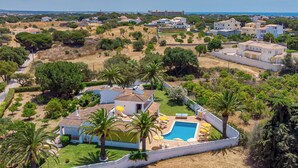 Ein Wohngebiet mit Swimmingpool, Palmen und Blick auf das Meer.