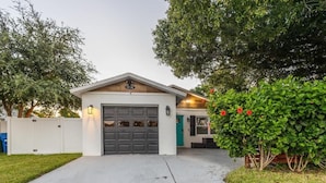 A single-story house with a garage, a front porch, and a well-maintained lawn. - Spacious 3-BR Home with Patio, Firepit & BBQ! (Largo)