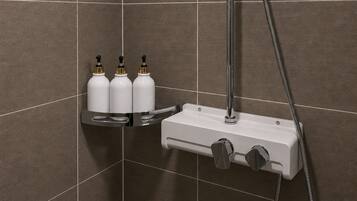 A shower area with a handheld showerhead, a wall-mounted faucet, and a soap dispenser shelf.