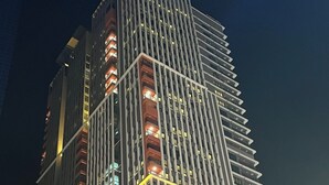 A tall, modern building with a grid-like facade and illuminated windows. - Haeundae Lamer Stay (Busan)