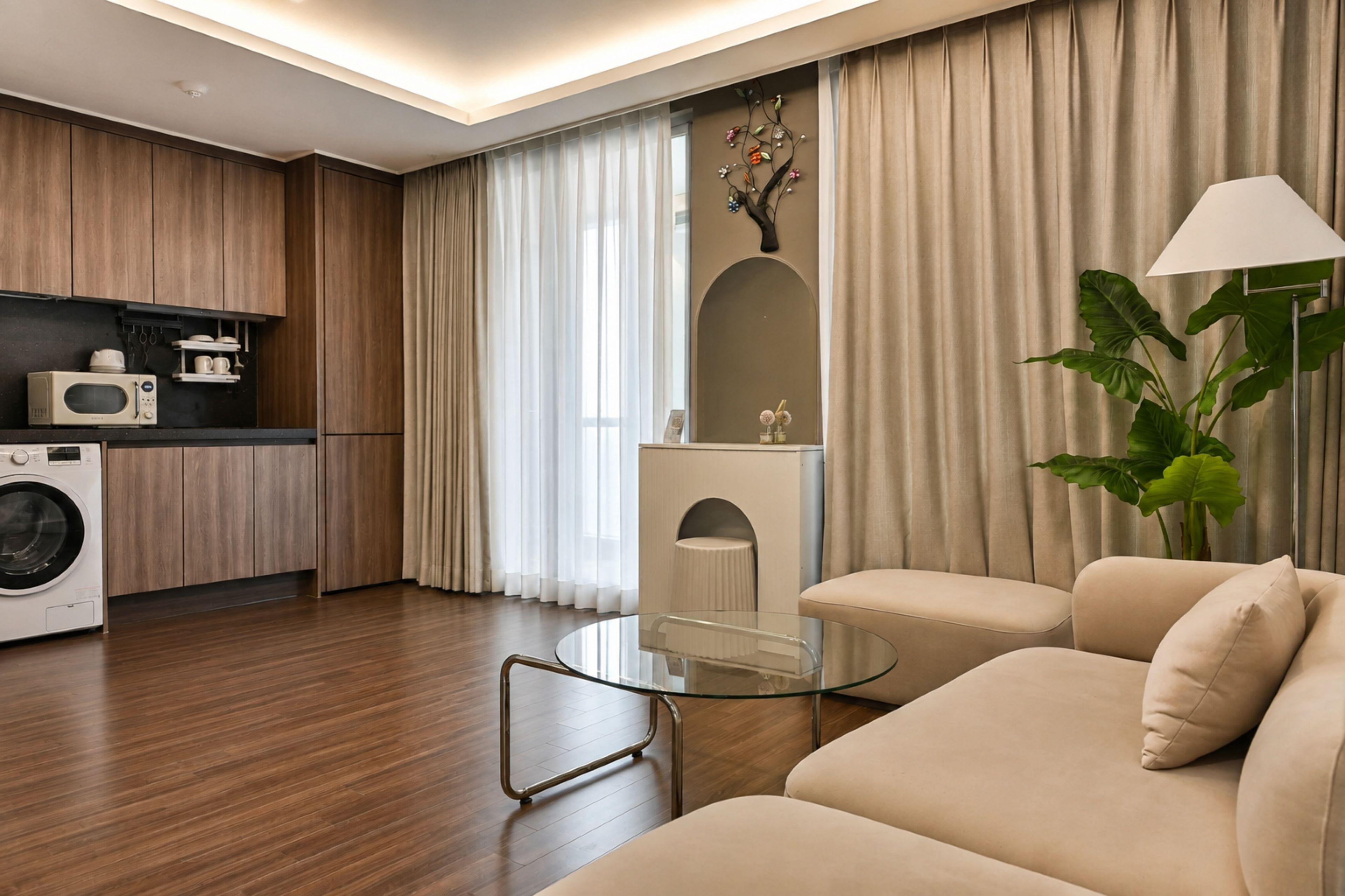 A modern living room with a sofa, a glass coffee table, and a large plant.