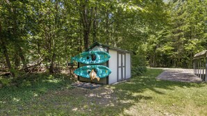 A small cabin with two kayaks attached to its side.