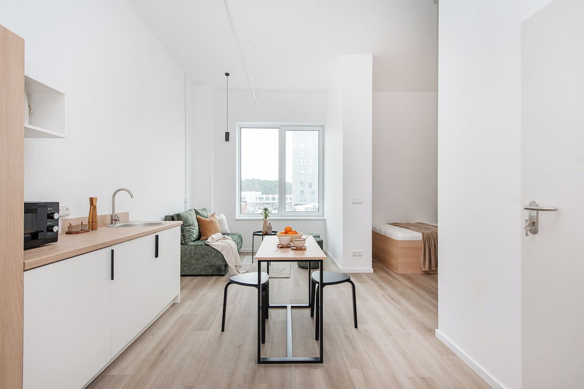 A modern apartment with a kitchen, dining area, and a living room.