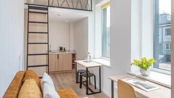 Un apartamento moderno con habitación estilo loft, cocina y comedor.