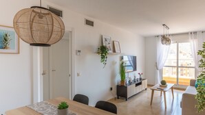 A modern living room with a sofa, a dining table, and a TV. - Apartment Catania in Aguadulce - Almeria. Equipped, elegant, and with sea views (Aguadulce)