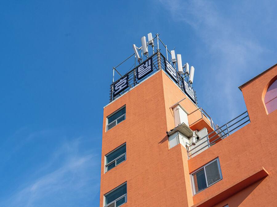 Un edificio de varios pisos con un cielo azul despejado al fondo.