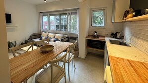 A modern kitchen with a dining area, a built-in oven, and a window overlooking the city. - Spectacular for 2 people in Mar del Plata, steps away from the beach. (Mar del Plata)