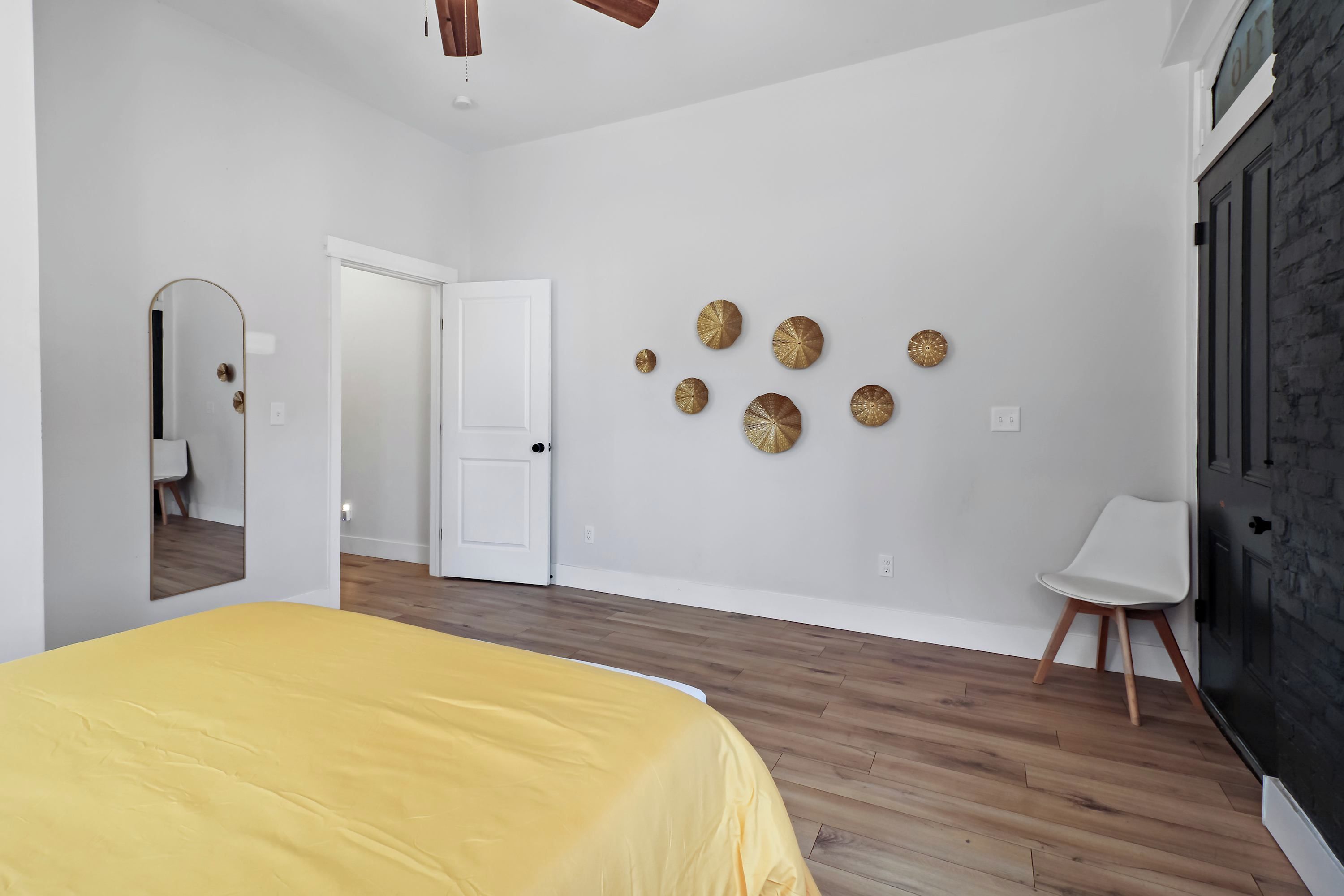 Une chambre à coucher avec un lit, une porte, une chaise et des éléments décoratifs sur les murs.