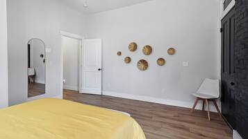 Une chambre à coucher avec un lit, une porte, une chaise et des éléments décoratifs sur les murs.
