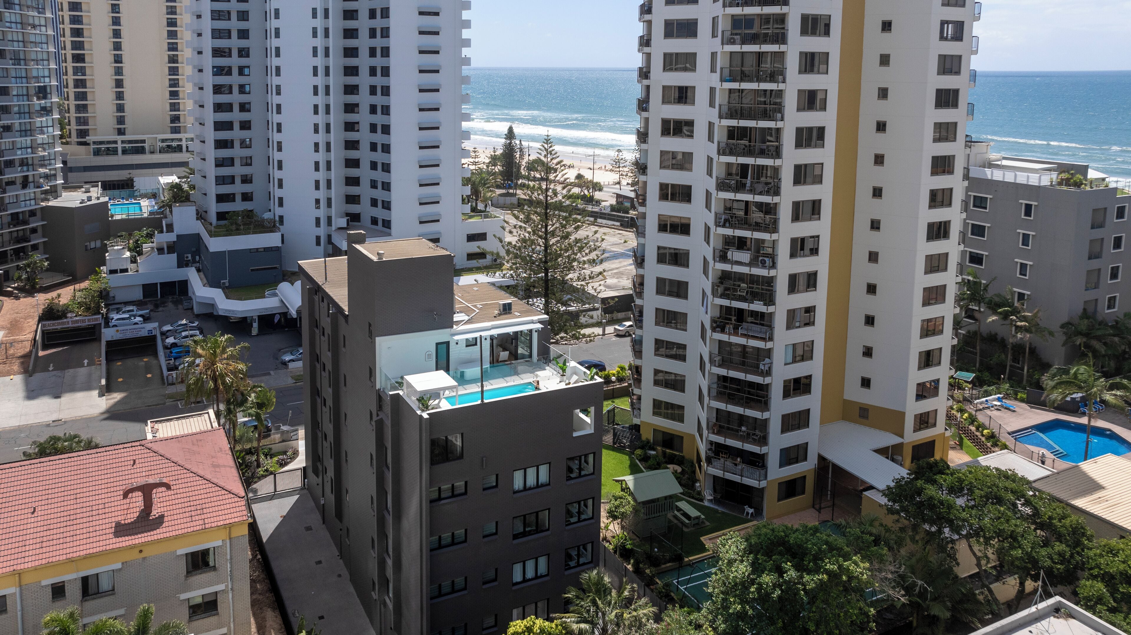 Un hôtel de grande hauteur doté de nombreux balcons, d’une piscine sur le toit et offrant une vue sur la plage et l’océan.