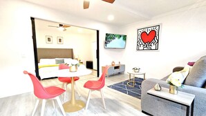 Une chambre d’hôtel moderne dotée d’un coin repas, d’un canapé et d’une télévision.