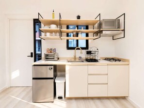 Una cocina moderna con horno integrado, un lavabo y un refrigerador compacto.
