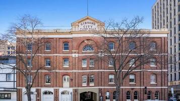 A historic red brick building with a sign reading "Gibson's City Flour Mills."