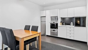 A modern kitchen with white cabinets, a built-in oven, and a microwave. - Gibson's Mill 1 Bedroom Warehouse Apartment with Atrium
View - 204 (Hobart)