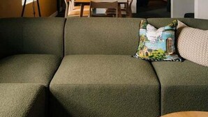 A cozy living room with a green sofa, a lamp, and a staircase leading to another room. - Gibson's Mill 3 Bedroom Loft Penthouse with Private
Balcony&Waterfront Views-301 (Hobart)