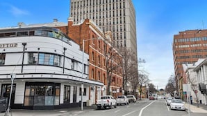 A hotel with a curved facade, a prominent sign, and a parking lot with vehicles. - Gibson's Mill 3 Bedroom Loft Penthouse with Private
Balcony&Waterfront Views-301 (Hobart)