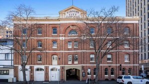 A historic red brick building with a sign reading "Gibson's City Flour Mills."